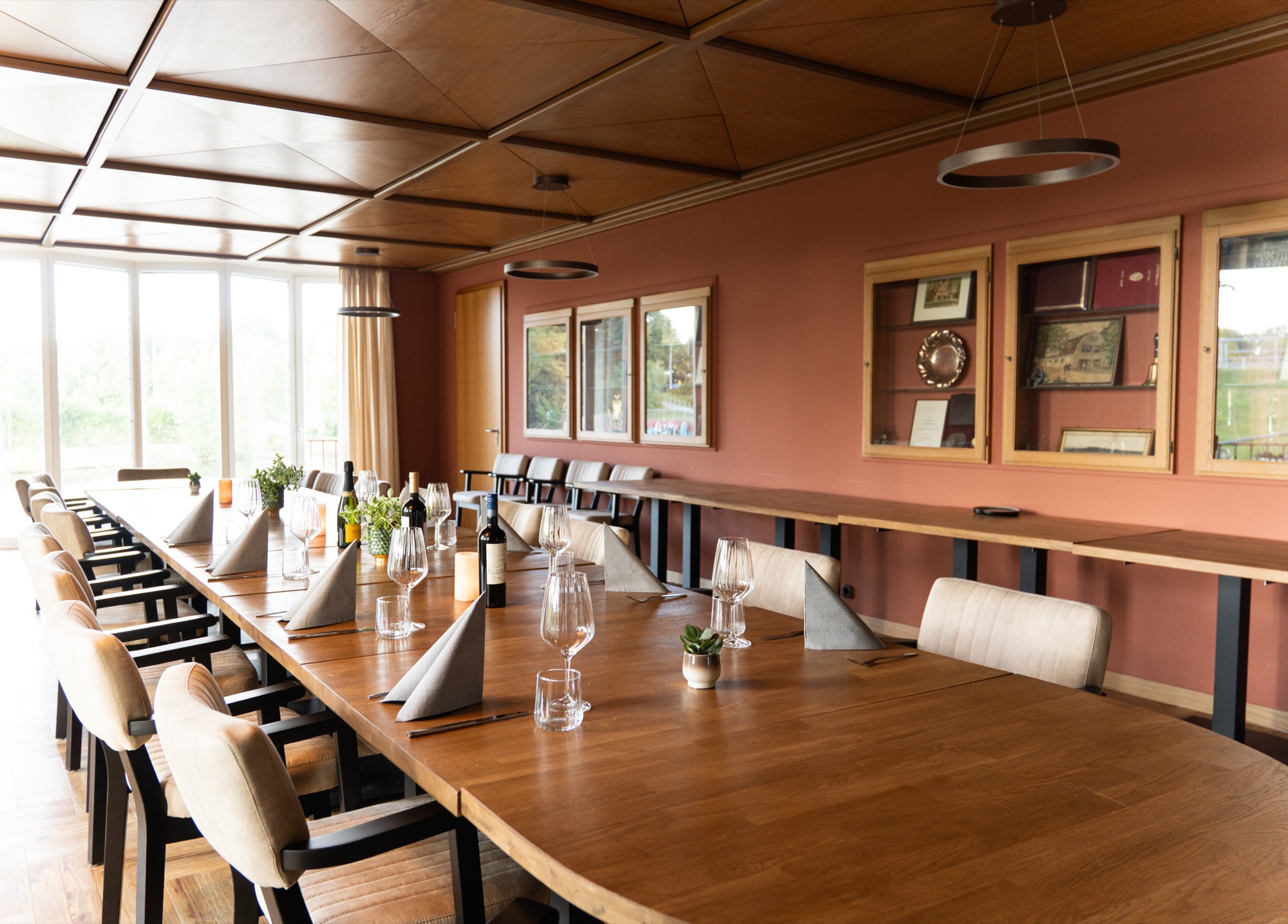 Eventraum mit langer Tafel und Vitrinen mit Ruderklub-Erinnerungsstücken an der Wand