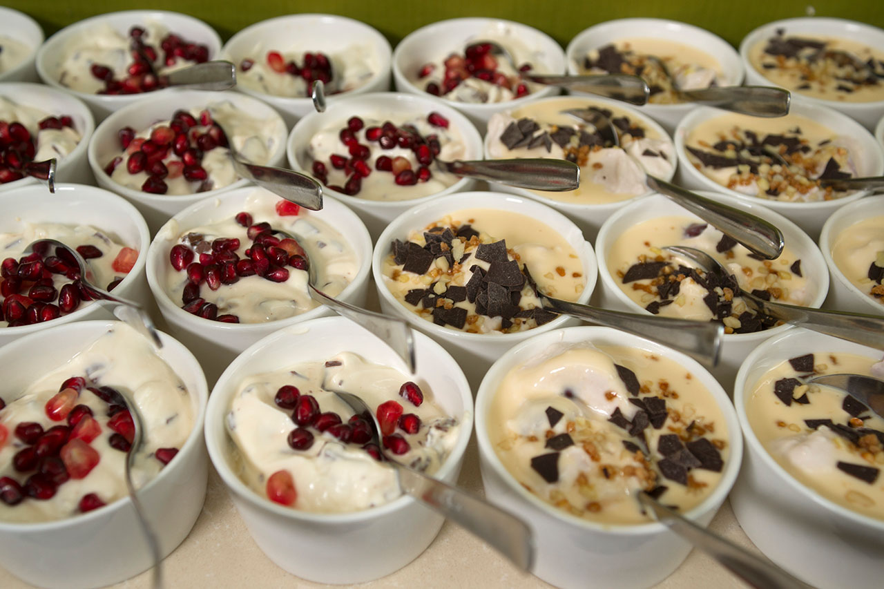 Dessert-Schälchen mit Sahnecreme, garniert mit Granatapfelkernen und Schokoladensplittern