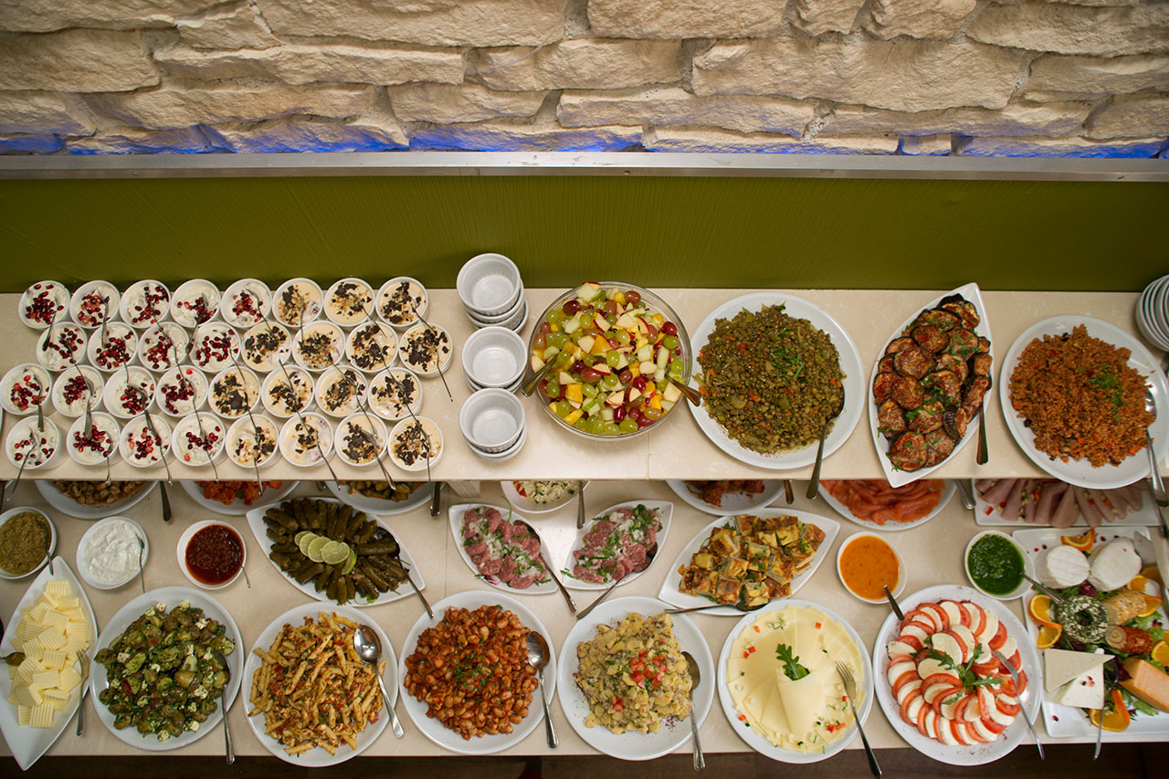Reich gedecktes Frühstücksbüfett mit Salaten, Antipasti und Käseplatten von oben