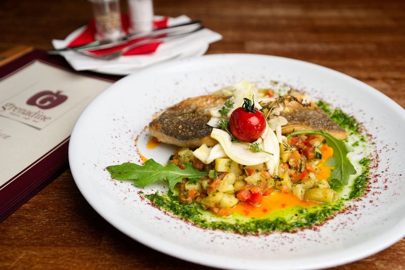 Angerichteter Fischteller mit Gemüse und Kräutersauce